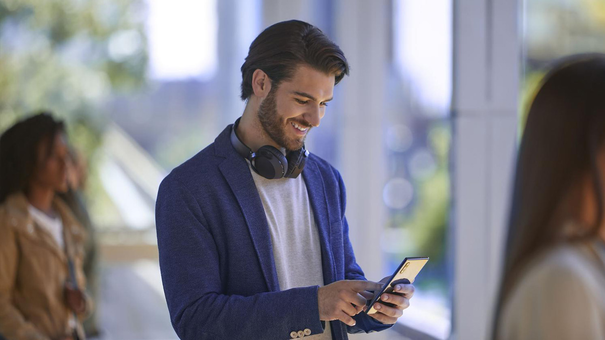 A man smiling at his phone